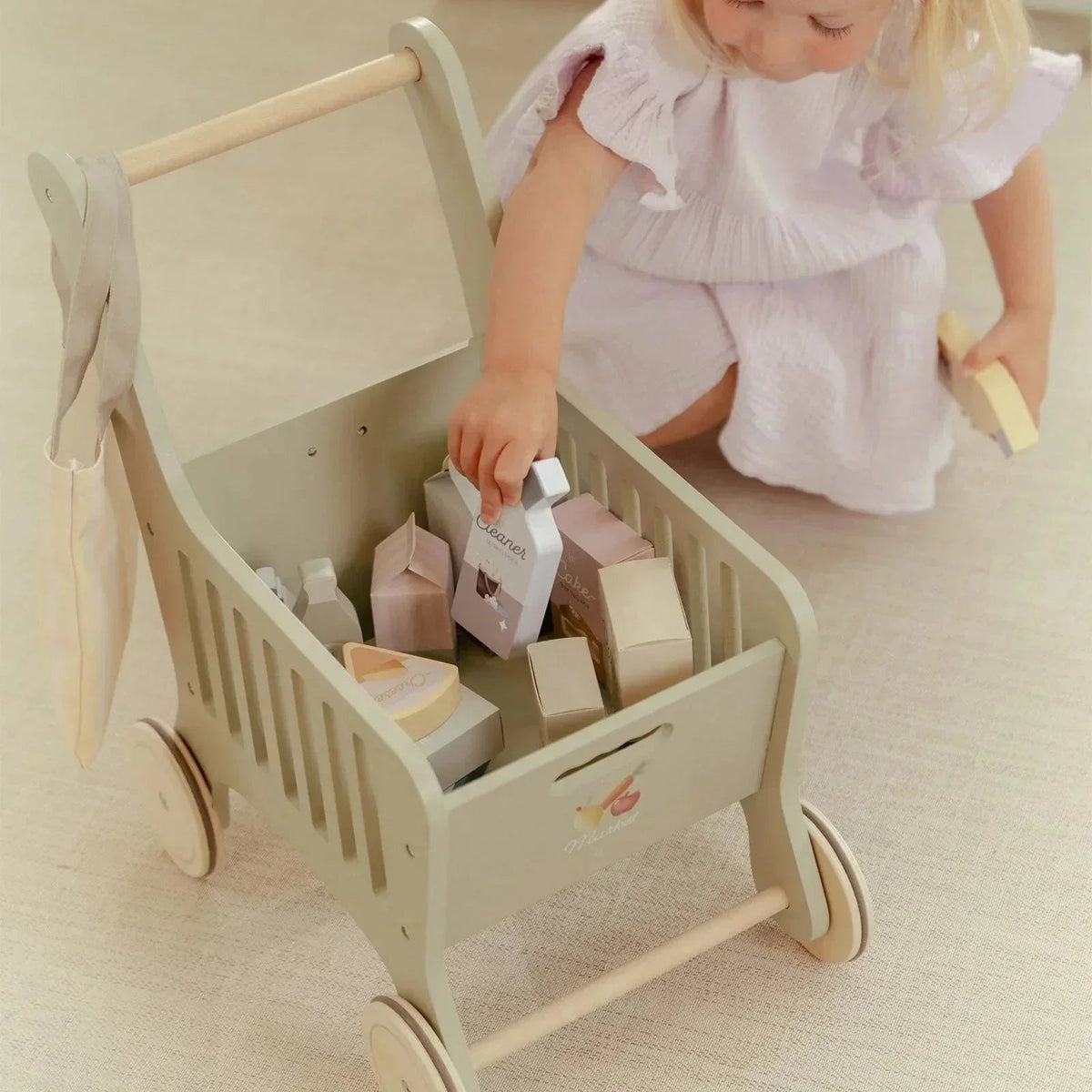 Little Dutch wooden shopping cart toy with play food for toddlers.
