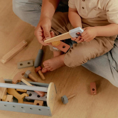 Child and adult playing with Little Dutch Tool Box wooden toy set on a light wooden floor